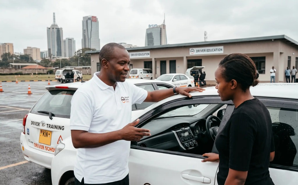 AMDA instructor briefing a student beside a driver training vehicle at a Nairobi centre